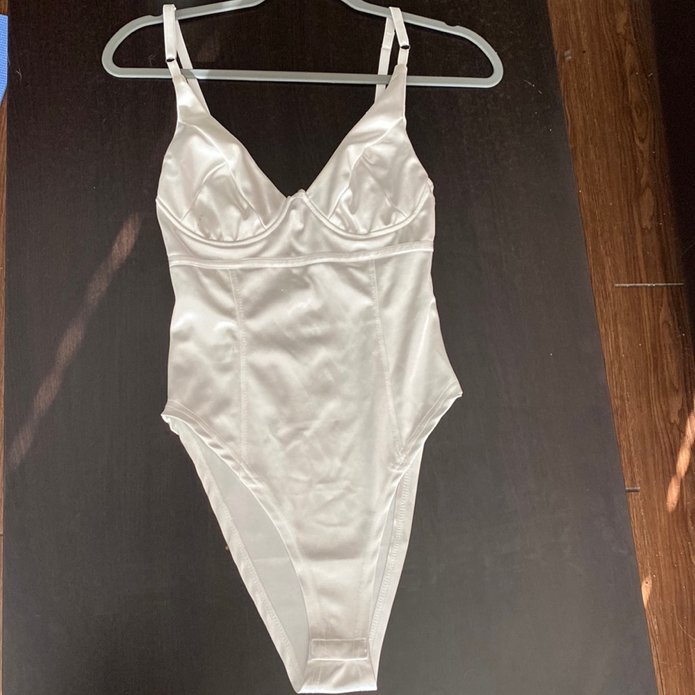 White, fitted, shiny, deep V-neck body suit in size small